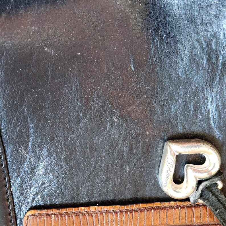 May include: Black leather wallet with a silver heart-shaped charm that says "Dooney & Bourke".