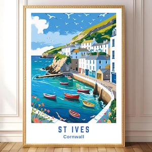 May include: A framed art print of St Ives, Cornwall. The artwork depicts a coastal scene with blue water, colorful boats, and white buildings. The sky is blue with white clouds and seagulls. The print is in a gold frame.