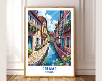 May include: A framed art print featuring a colorful illustration of Colmar, France. The artwork depicts a canal lined with vibrant buildings, flowers, and a bridge under a bright blue sky. The text "COLMAR FRANCE" is at the bottom.