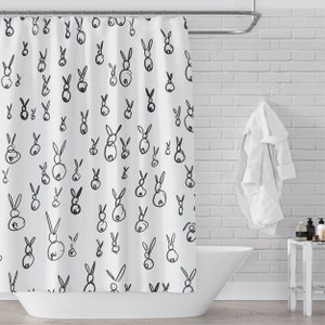 May include: White shower curtain with a black and white rabbit pattern. The rabbits are drawn in a simple, minimalist style.