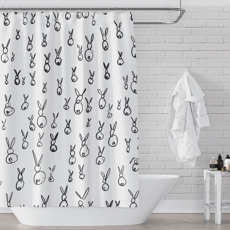 May include: White shower curtain with a black and white rabbit pattern. The rabbits are drawn in a simple, minimalist style.