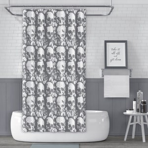 May include: A grey shower curtain with a white skull pattern. The text "Take it all off and get clean" is on a framed sign above a white bathtub.