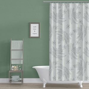 May include: A white shower curtain with a gray fern and flower pattern. The text "wash rinse & repeat" is on a framed sign on the wall.