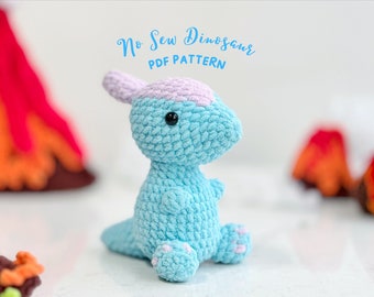 May include: A light blue crocheted dinosaur toy with pink accents. The toy is sitting on a white surface with a red and orange background. The text "No Sew Dinosaur PDF PATTERN" is written above the toy.