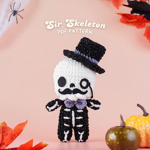 Pode incluir: Boneca de esqueleto de crochê usando cartola, monóculo e bigode. A boneca é preta e branca com uma gravata borboleta roxa. O texto "Sir Skeleton PDF Pattern" está no topo. Abóboras e folhas de outono no fundo.