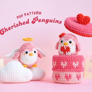 Peut inclure: Deux jouets en crochet amigurumi de pingouin rose. Un pingouin porte un halo et a des ailes. L'autre pingouin tient un cœur rouge et se trouve dans une boîte en crochet en forme de cœur rose. Le texte "PDF PATTERN Cherished Penguins" est en haut de l'image.