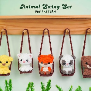 May include: A wooden shelf displays five crocheted animal toys in swings. The animals include a yellow dog, white cat, orange fox, panda, and brown bear. The text "Animal Swing Set PDF Pattern" is at the top.