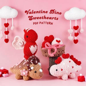 May include: A collection of handmade crochet Valentine's Day decorations, including dinosaurs, clouds with hanging hearts, and a cupcake. The text "Valentine Dino Sweethearts PDF Pattern" is displayed in a decorative font on a pink background.