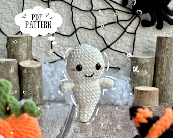 Op de afbeelding: Een witte gehaakte geest met een glimlachend gezicht en zwarte ogen. De geest staat op een houten oppervlak met een spinnenweb op de achtergrond. De tekst "PDF PATTERN" staat op een witte wolk.