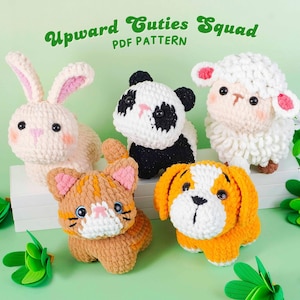 May include: A collection of five crocheted animal figures: a bunny, panda, sheep, cat, and dog. The bunny is cream-colored with pink accents, the panda is black and white, the sheep is white with pink ears, the cat is orange, and the dog is orange and white. Text reads "Upward Cuties Squad PDF Pattern."