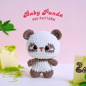 May include: A crocheted baby panda amigurumi toy with brown ears and paws, white fur, and black eyes. The toy is sitting on a white surface with a pink background. The text "Baby Panda PDF Pattern" is written in pink letters above the toy.