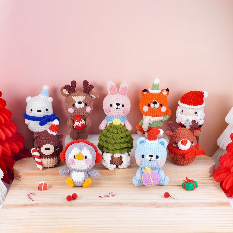 May include: A collection of handmade crochet Christmas ornaments. The ornaments include a polar bear, reindeer, bunny, fox, Santa, bear, penguin, and a blue bear. Each ornament is uniquely designed with festive colors and details, perfect for holiday decor.