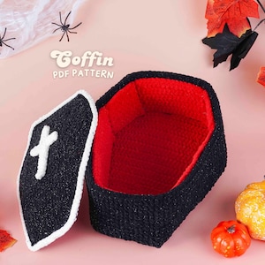May include: A black and red crochet coffin with a white cross on the lid. The coffin is open, revealing a red interior. The text "Coffin PDF Pattern" is visible. Decorative spiders, leaves, and pumpkins are also present.