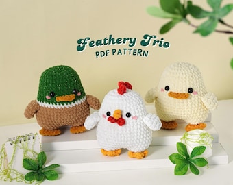 Puede incluir: Tres figuras de aves de ganchillo: un pato, una gallina y un pollito. El pato es verde, marrón y blanco. La gallina es blanca con una cresta roja. El pollito es amarillo. El texto "Feathery Trio PDF PATTERN" está en la parte superior.