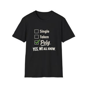 Op de afbeelding: Zwart t-shirt met de tekst "Single, Taken, Poly" met een groen vinkje naast "Poly" en de woorden "YES, WE ALL KNOW." in het wit. Het shirt heeft een ronde hals en korte mouwen.