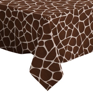 May include: Brown and white tablecloth with a giraffe print pattern.