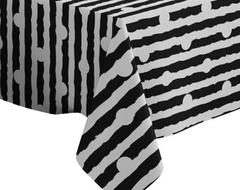 May include: Black and white striped tablecloth with a pattern of white circles. The tablecloth is made of a soft, durable fabric and is perfect for any occasion.