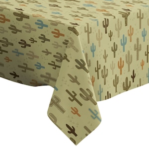 May include: A beige tablecloth featuring a repeating pattern of cacti in shades of brown, blue, and orange. The cacti vary in size and design, creating a desert-themed aesthetic. The tablecloth is folded over a surface, showcasing the fabric's texture and pattern.