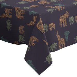 May include: A navy blue tablecloth featuring a repeating pattern of ornate elephants in shades of gold and teal. The elephants are intricately detailed with swirling designs. The tablecloth is made of a textured fabric.