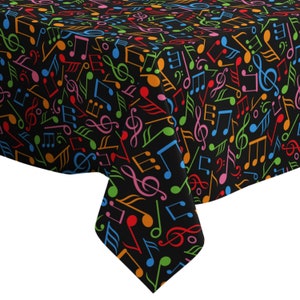 Può includere: Tovaglia nera con un motivo di note musicali colorate. Le note sono di vari colori, tra cui rosso, arancione, giallo, verde, blu e viola.