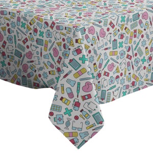 May include: White tablecloth with a repeating pattern of colorful medical icons, including pills, bandages, thermometers, stethoscopes, and hearts.
