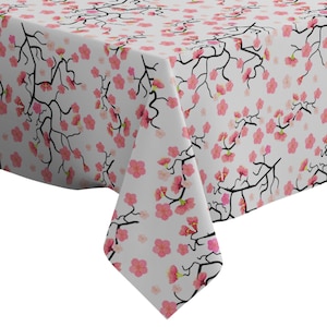 Op de afbeelding: Witte tafelkleed met een roze en zwart kersenbloesem patroon. Het tafelkleed is rechthoekig en gemaakt van een zachte, gladde stof.