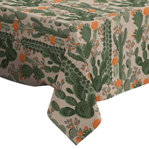 May include: A beige tablecloth with a repeating pattern of green cactus plants and orange flowers.