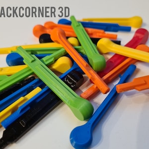 May include: A pile of colorful plastic tools, including green, yellow, orange, red, and blue. The tools are all different shapes and sizes, and some have rounded ends. The tools are arranged in a random pattern on a white surface. BACKCORNER 3D is printed on the top of the image.