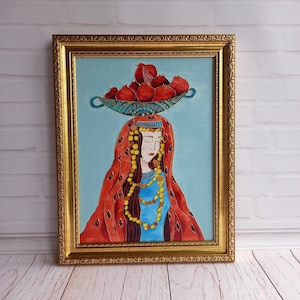 Peut inclure: Peinture encadrée d'une femme aux yeux fermés, vêtue d'une robe bleue et d'un châle rouge. Elle porte un bol turquoise rempli de grenades rouges sur la tête. L'œuvre est sur fond bleu clair et encadrée d'or.