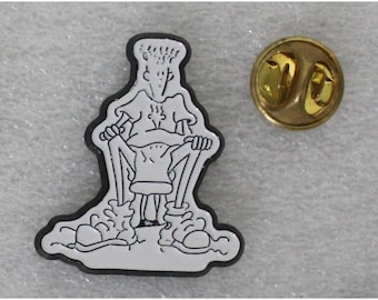 May include: A black and white enamel pin featuring a cartoon character riding a pogo stick. The pin has a gold metal backing with a safety clasp.