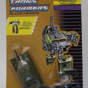 Puede incluir: Un robot de juguete Transformers verde y negro, Brawl, del equipo Decepticon Combaticons. El juguete se transforma de un tanque a un robot. El empaque presenta el texto "Combaticons" y "Brawl".