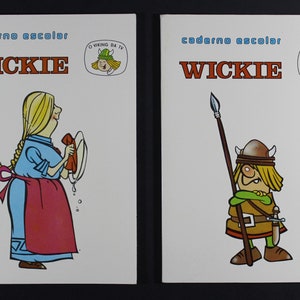 May include: Two colorful covers of school notebooks featuring the cartoon character Wickie the Viking. The left cover shows Wickie's mother washing dishes. The right cover shows Wickie holding a spear and a sword.
