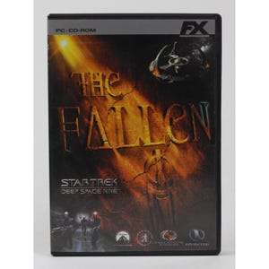 May include: A black PC CD-ROM case with a yellow and orange background image. The text "The Fallen" is in large, bold letters. The text "Star Trek Deep Space Nine" is in smaller letters below the title. The case has a logo for FX, Collective Studios, and Infinite Loop.