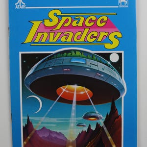 Puede incluir: Una portada de juego Space Invaders azul y amarilla con una nave espacial y una luna en el fondo.
