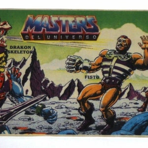 May include: A vintage Masters of the Universe trading card featuring Skeletor riding a red dragon, Fist, and Man-At-Arms. The card has a green background with the text "Masters of the Universe" and "Mattel" in the bottom right corner.