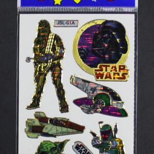 May include: A sheet of Star Wars stickers featuring Chewbacca, Darth Vader, a spaceship, Yoda, and Boba Fett. The stickers are holographic and have a gold background.