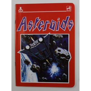 Puede incluir: Caja de juego Atari Asteroids roja. La portada muestra una nave espacial esquivando asteroides en el espacio. El título del juego "Asteroids" está en letras grandes, moradas y estilizadas. El logotipo de Atari está en la esquina superior izquierda.