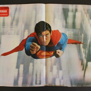 May include: A vintage poster featuring Superman flying through a city skyline. The poster is titled "Superman" and "Proyectil humano".