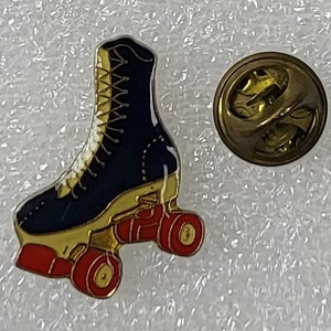 Puede incluir: Un pin de patín de ruedas azul y dorado con ruedas rojas. El pin tiene una parte posterior dorada con un pasador de seguridad.