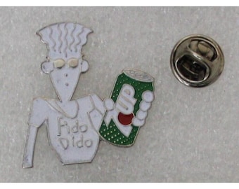 May include: A white enamel pin featuring a cartoon character holding a green can of soda with the word "Fido Dido" on the can.
