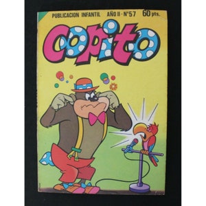 Könnte beinhalten: Ein Vintage-Comic-Cover mit einem Cartoon-Affen, der ein Clownskostüm und einen Hut trägt und sich die Ohren zuhält. Der Affe steht vor einem Mikrofon, in das ein Papagei singt. Der Comic heißt "Copito" und stammt aus dem zweiten Jahr der Veröffentlichung, Ausgabe Nummer 57.