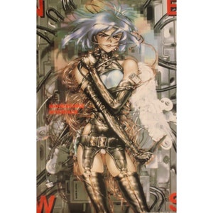 May include: A woman with blue hair and a white top is wearing a black leather outfit with silver accents. She is standing in a futuristic setting with wires and cables surrounding her. The text "MANI-MACHINE INTERFACE" is visible in the background.