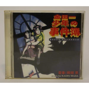 May include: A CD case with a black and white image of two anime characters. The title of the CD is "少年の事件簿" (Shonen no Jikenbo) which translates to "The Boy's Case Files". The text "オリジナル・サウンドトラック" (Original Soundtrack) is also visible. The music is by Kaoru Wada.