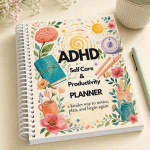 May include: A spiral-bound planner with a white cover featuring watercolor illustrations of a brain, sun, timer, mugs, and flowers. The text reads: ADHD Self Care & Productivity PLANNER, a kinder way to notice, plan, and begin again.