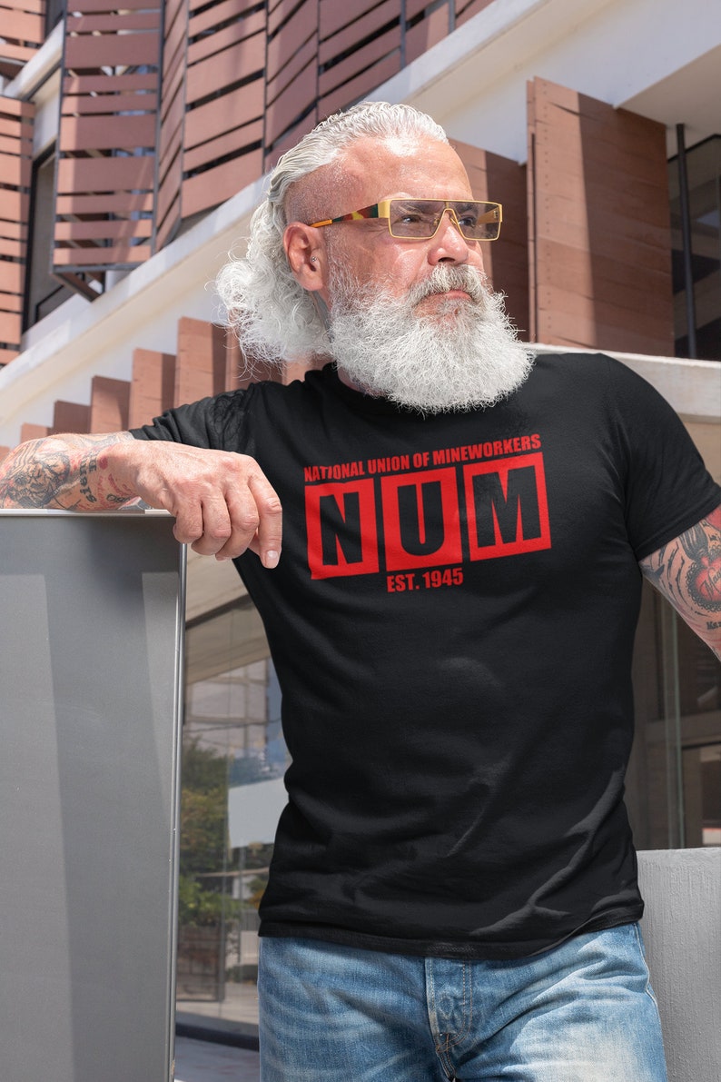 May include: A black t-shirt with a red graphic that says "National Union of Mineworkers NUM Est. 1945".