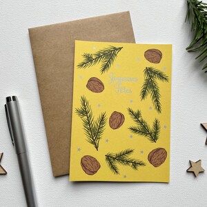 Carte étoiles argentées, illustration branches de sapin et noix, fond jaune, joyeuses fêtes, joyeux Noël, carte de voeux