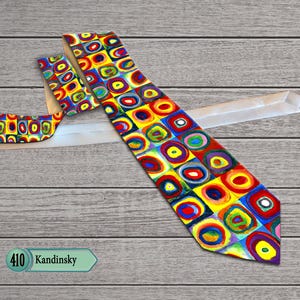 May include: A colorful necktie with a geometric design in red, yellow, blue, and green. The tie features a repeating pattern of squares with concentric circles. The text "410 Kandinsky" is in a green label.