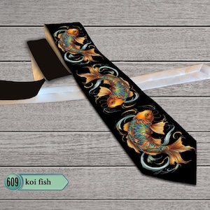 May include: A black necktie featuring a repeating pattern of three koi fish. Each fish is rendered in vibrant shades of orange, blue, and gold, depicted with flowing fins and surrounded by swirling white water accents. The tie has a white lining.