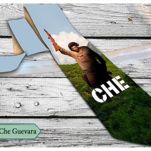以下が含まれることがあります： チェ・ゲバラの写真がプリントされたネクタイ。ネクタイは緑色で、白い文字で「CHE」と印刷されています。