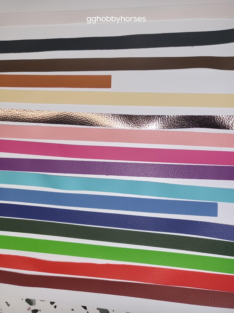 K&ouml;nnte beinhalten: Eine Auswahl an Lederstreifen in verschiedenen Farben, darunter Schwarz, Braun, Beige, Rosa, Lila, T&uuml;rkis, Blau, Dunkelblau, Gr&uuml;n, Rot und Weinrot. Die Streifen sind in Reihen auf einer wei&szlig;en Oberfl&auml;che angeordnet. gghobbyhorses steht oben im Bild.
